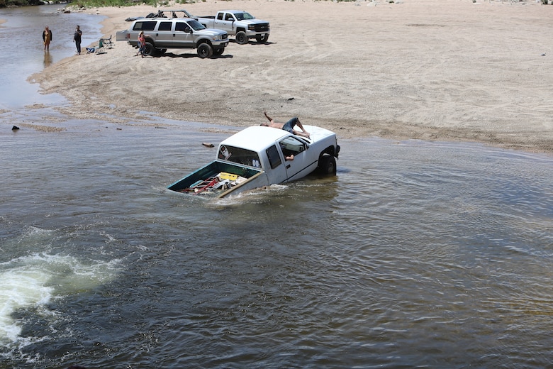 Driver of this vehicle awaits help from other drivers after becoming submerged in the Mojave River Dam's outlet May 17.