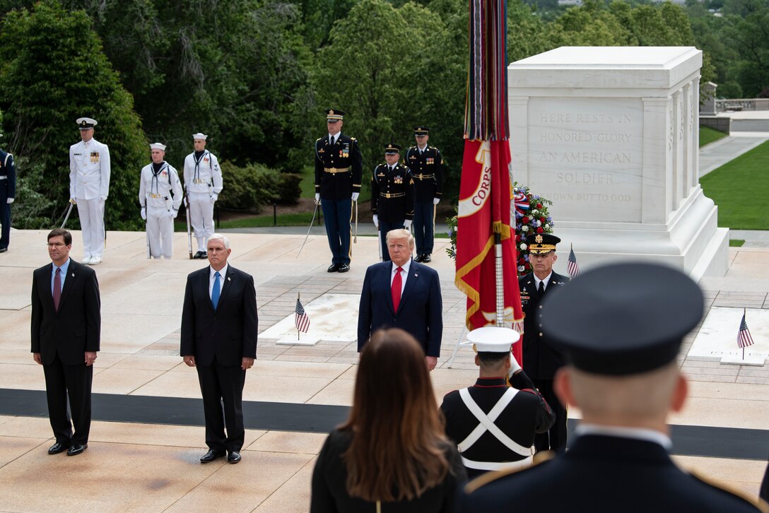 Four men stand attention at the Tomb of the Unknown Soldier.