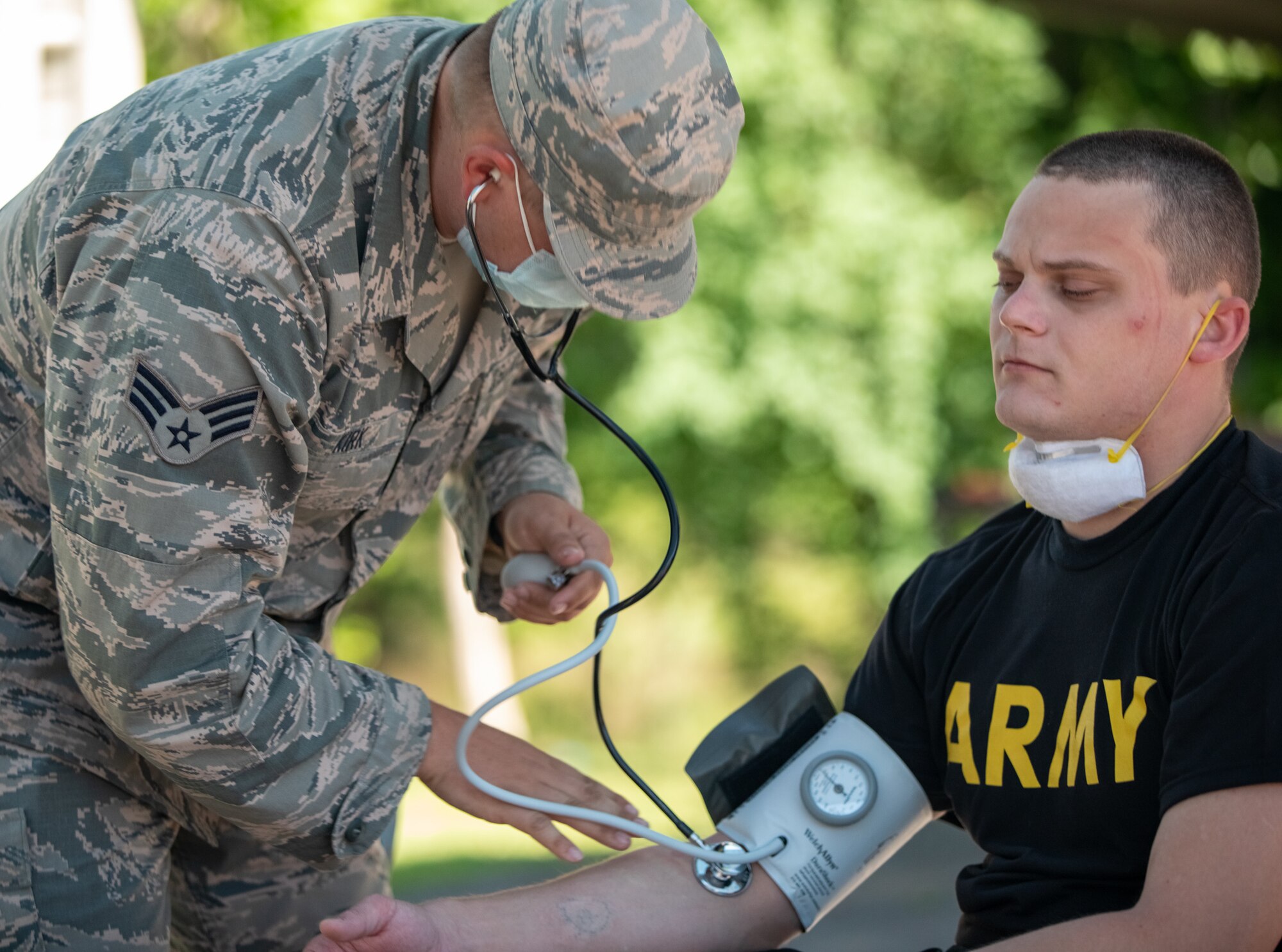 Senior Airman Tristan Kirk, a medic for Team 3 with Task Force 31, checks the vitals of a disinfection team specialist, May 1, 2020. The vitals of all Task Force 31 disinfection teams are checked before and after all disinfection operations. (Photo by U.S. Army Sgt. Jaccob Hearn)