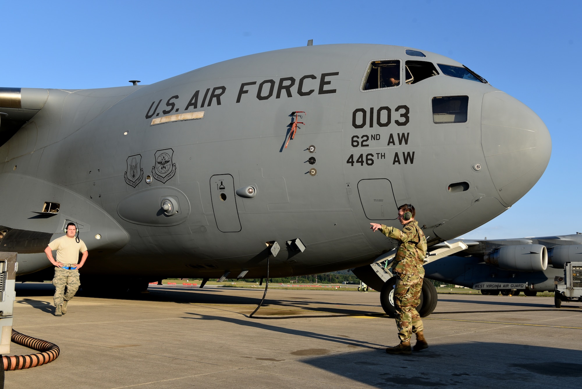 U.S. Air Force Staff Sgt. Taylor J. Eide, right, 721st Aircraft Maintenance Squadron quality assurance inspector, signals to Tech. Sgt. Michael Cain, 721st AMXS flight line expeditor, upon approaching the C-17 Globemaster III aircraft at Ramstein Air Base, Germany, May 21, 2020.