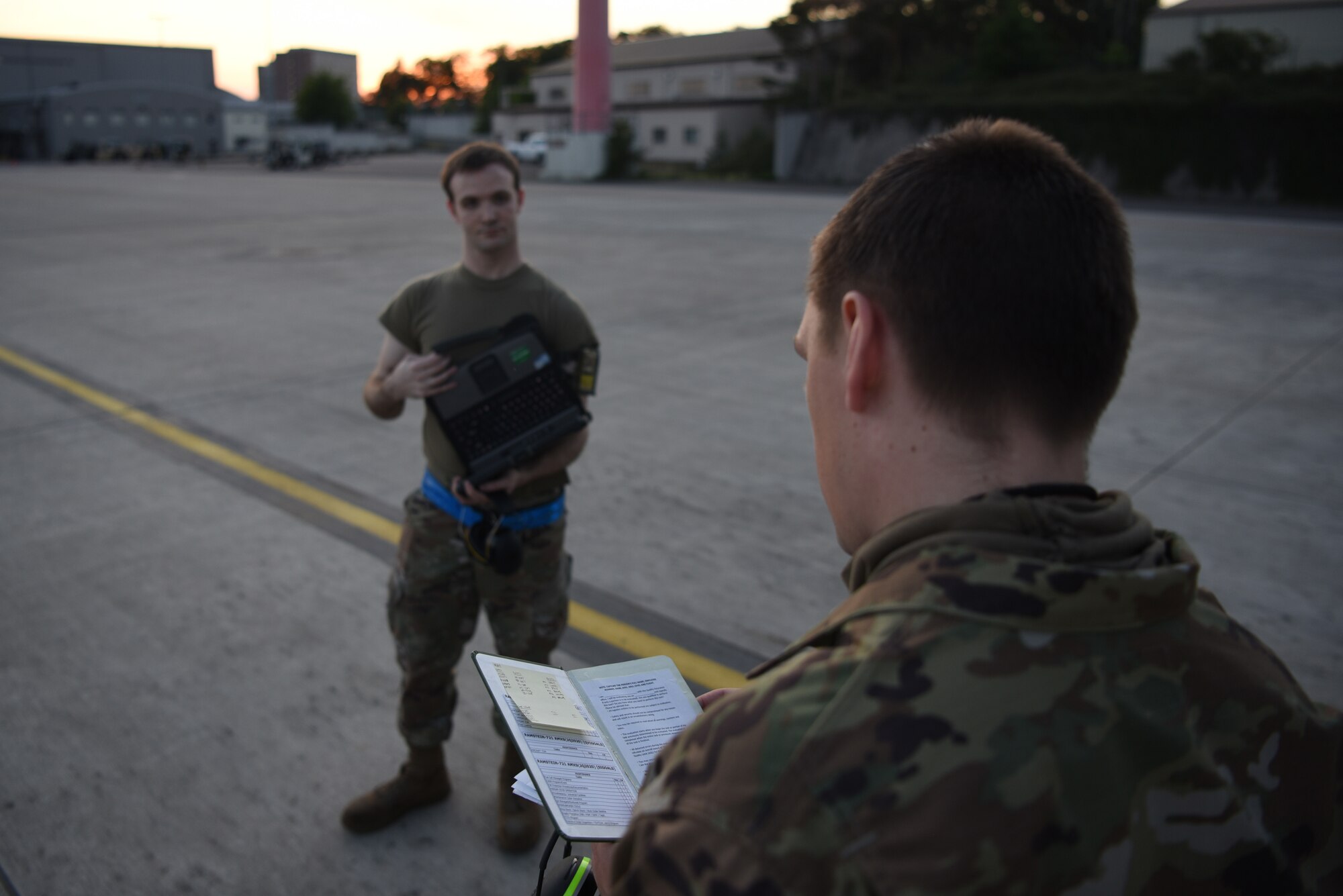 U.S. Air Force Staff Sgt. Taylor J. Eide, right, 721st Aircraft Maintenance Squadron quality assurance inspector, gives a personal evaluation brief to Staff Sgt. Theodore Ellis, 721st AMXS crew chief craftsman, at Ramstein Air Base, Germany, May 21, 2020.
