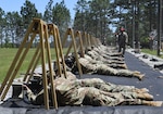 Airmen lay on ground firing weapons