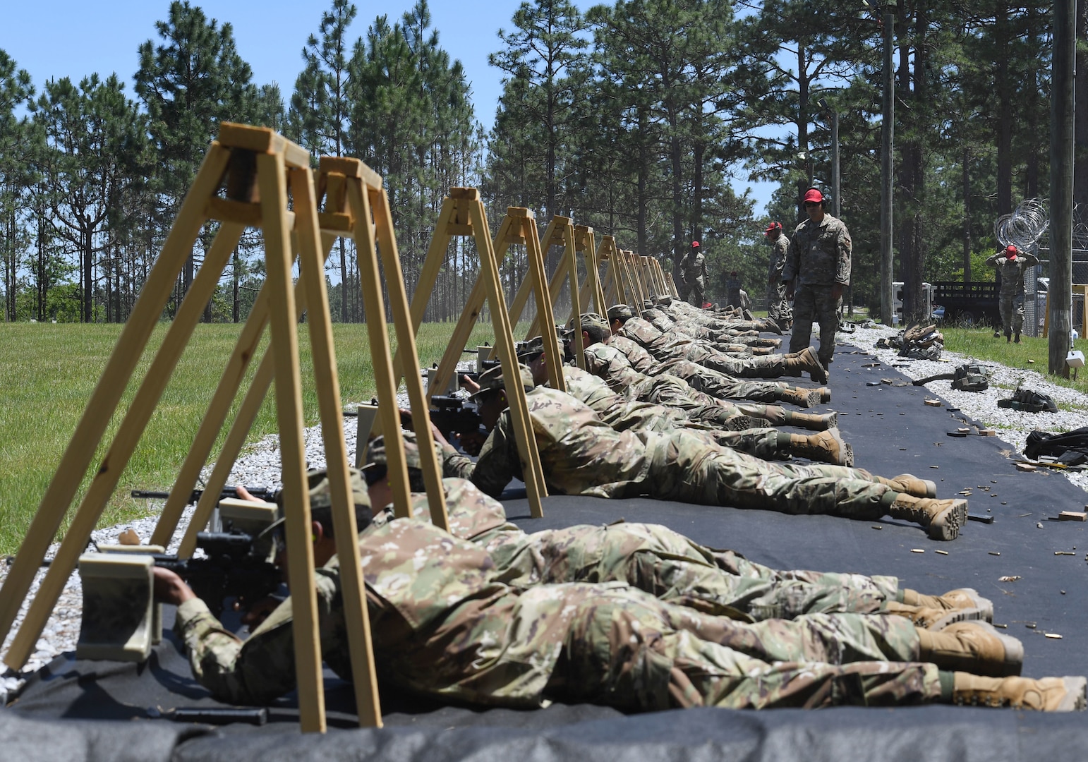 Airmen lay on ground firing weapons