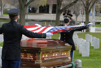 Spc. Austin Dycha and Sgt. Nikole Clark, members of the New York National Guard Military Funeral Honors Team, remove the flag of the United States from the casket of U.S. Army Spc. Levelzo Lyles at his funeral in Lackawanna, New York, May 14, 2020. Dycha and Clark wore cloth face masks as part of precautions used during military funerals to prevent the spread of COVID-19.