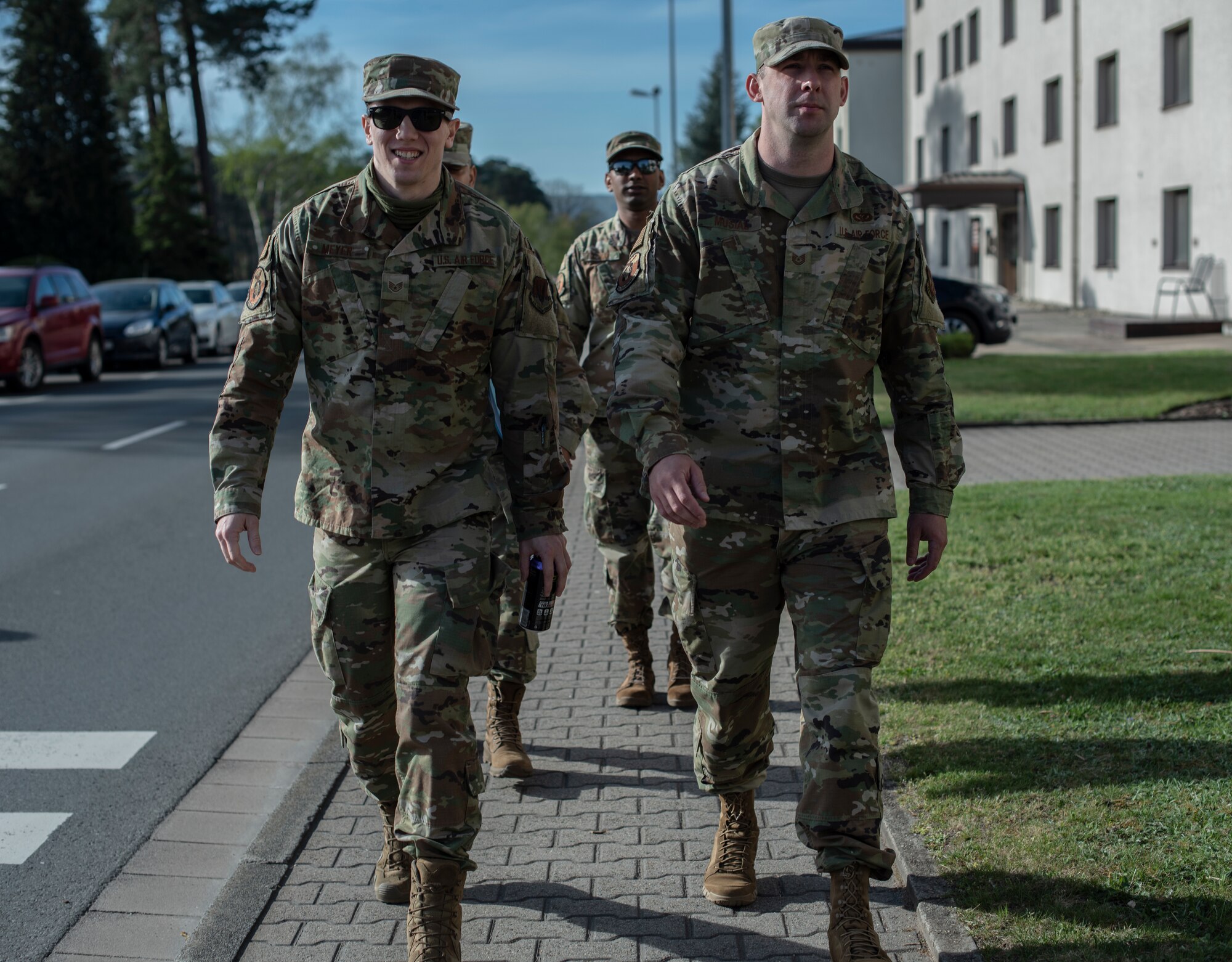 A team of Airman Dormitory Leaders walk down a sidewalk at Ramstein Air Base, Germany, April 15, 2020.
