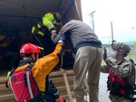 Virginia National Guard Soldiers help the Roanoke Police and Fire-EMS Swift Water Rescue Team evacuate more than 110 people from a hotel threatened by rising floodwaters May 21, 2020, in Roanoke, Virginia. Soldiers assigned to the Lynchburg-based 1st Battalion, 116th Infantry Regiment, 116th Infantry Brigade Combat Team, used medium tactical trucks capable of traveling through high water to transport the victims and pets to safety. (Photo courtesy Roanoke Fire-EMS)