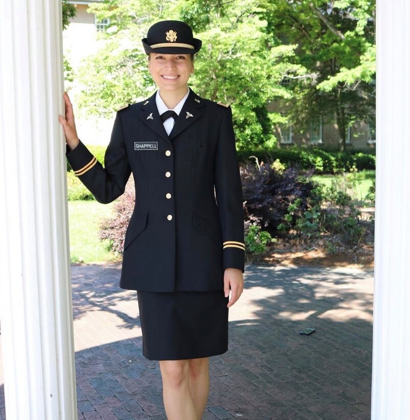 Army officer in dress uniform poses for a photo in a doorway.