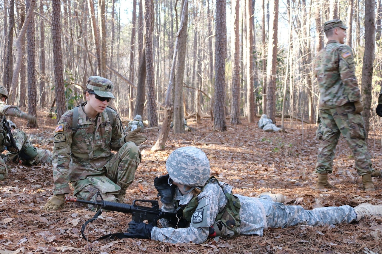Two Army ROTC cadets, one kneeling and one prone, participate in combat training.