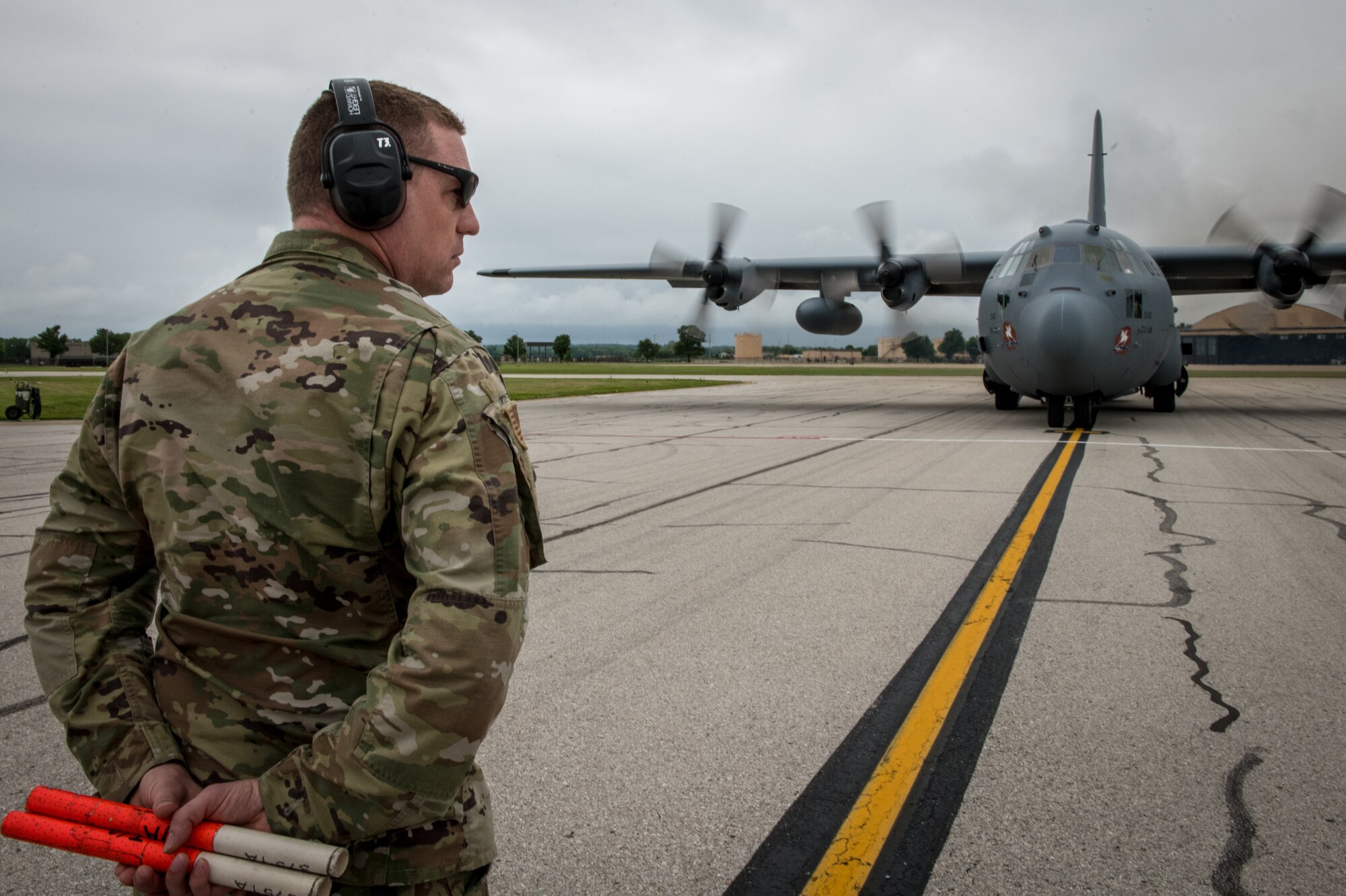 Capt. Aaron Wolfe, 932nd Maintenance Group operations officer, stands at the ready May 20, 2020, Scott Air Force Base, Illinois. Wolfe had the honor of marshaling in a C-130 with returning 932nd Medical Squadron nurses and technicians that were fighting on the frontlines of COVID-19. (U.S. Air Force photo by Christopher Parr)