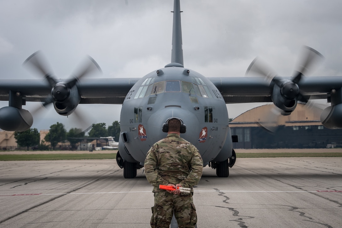 Capt. Aaron Wolfe, 932nd Maintenance Group operations officer, stands at the ready May 20, 2020, Scott Air Force Base, Illinois. Wolfe had the honor of marshaling in a C-130 with returning 932nd Medical Squadron nurses and technicians that were fighting on the frontlines of COVID-19. (U.S. Air Force photo by Christopher Parr)