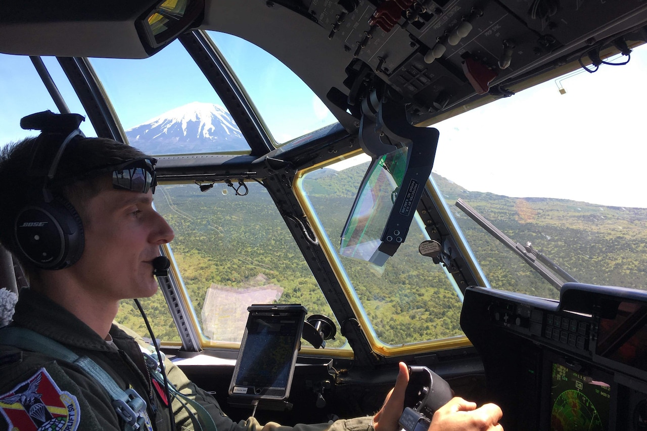 An Air Force pilot sits in a C-130J cockpit.