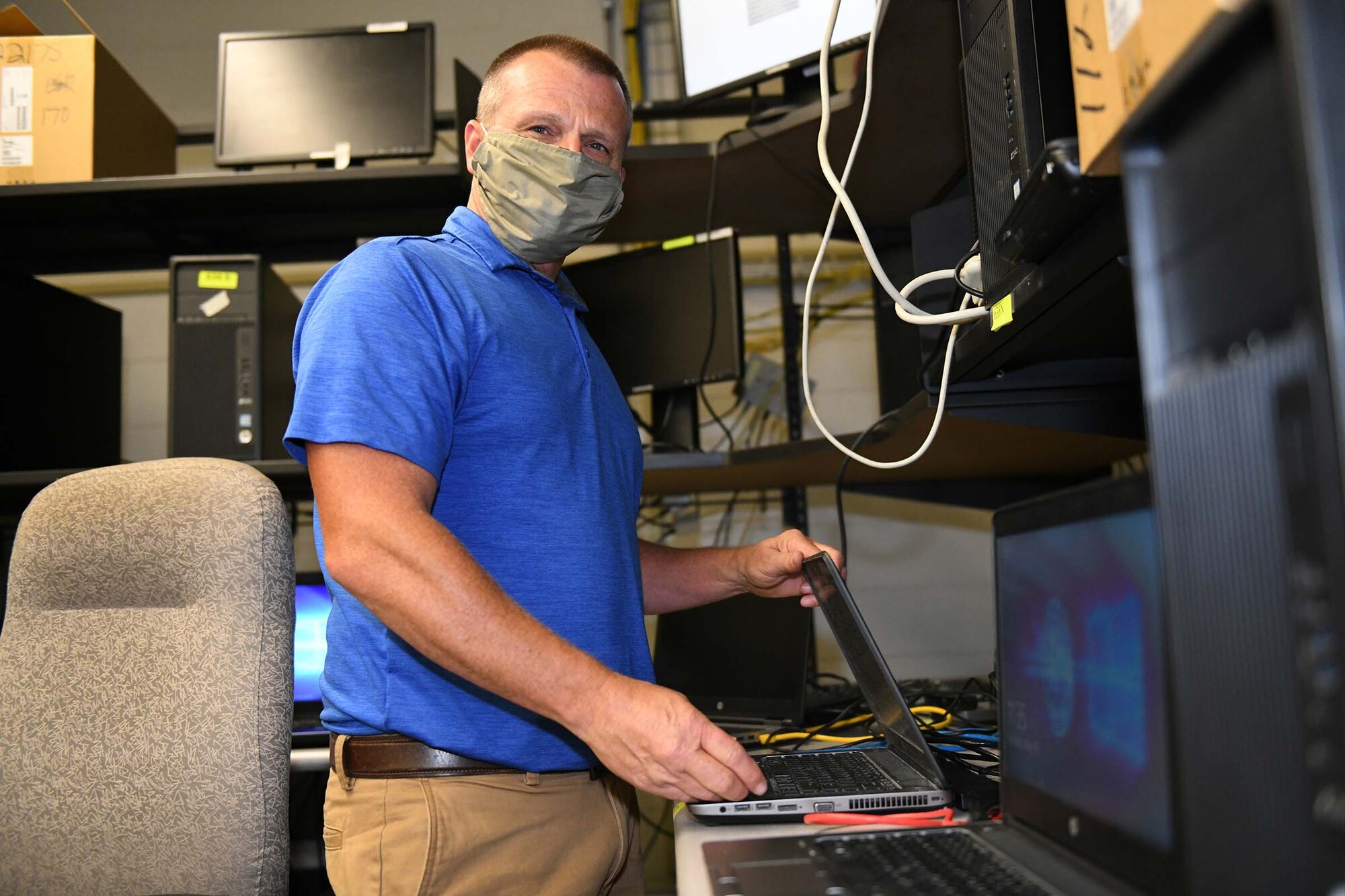 Keith Foskey, IT Support Team Lead, 638th Supply Chain Management Squadron, Robins, AFB, Georgia, replaces a laptop battery and reimages the laptop.