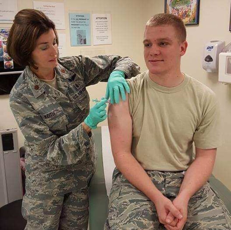Maj. Natalie Keith, 403rd Aeromedical Staging Squadron clinical nurse, delivers an immunization to Tech. Sgt. Zach Barnhill, 403rd ASTS medical technician. (courtesy photo from Lt. Col. Natalie McKee/ released with Tech. Sgt. Barnhill's approval)