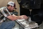 William Johnson, 533rd Commodities Maintenance Squadron, measures an aircraft part while working with the five-axis Versatech machine May 5, 2020, at Hill Air Force Base, Utah. The skilled engineers and technicians of the 533rd CMMXS in the Ogden Air Logistics Complex, design, prototype and manufacture thousands of critical components annually, that can’t be found anywhere else in the world. The parts are manufactured in order to bridge a gap in the regular supply system, when there’s no contract in place from an outside source.