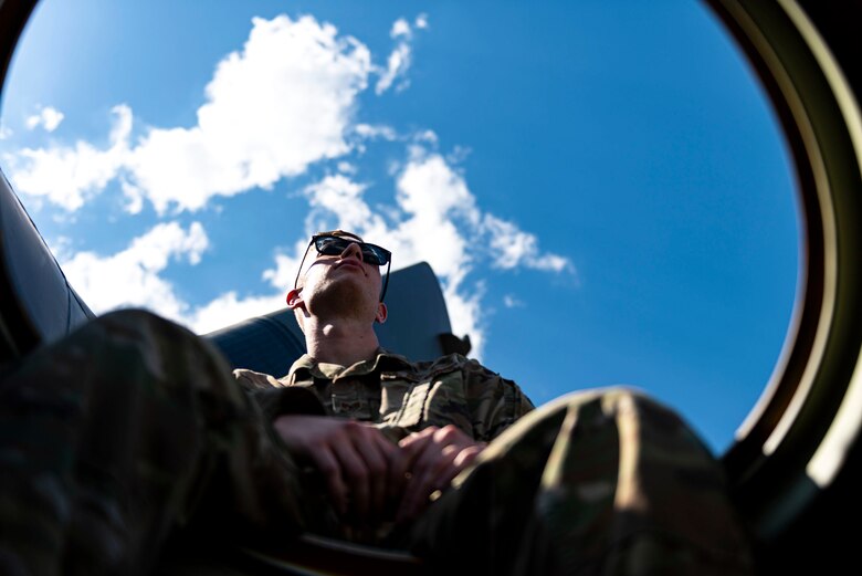Photo of Airman looking out of an HC-130J Combat King II.