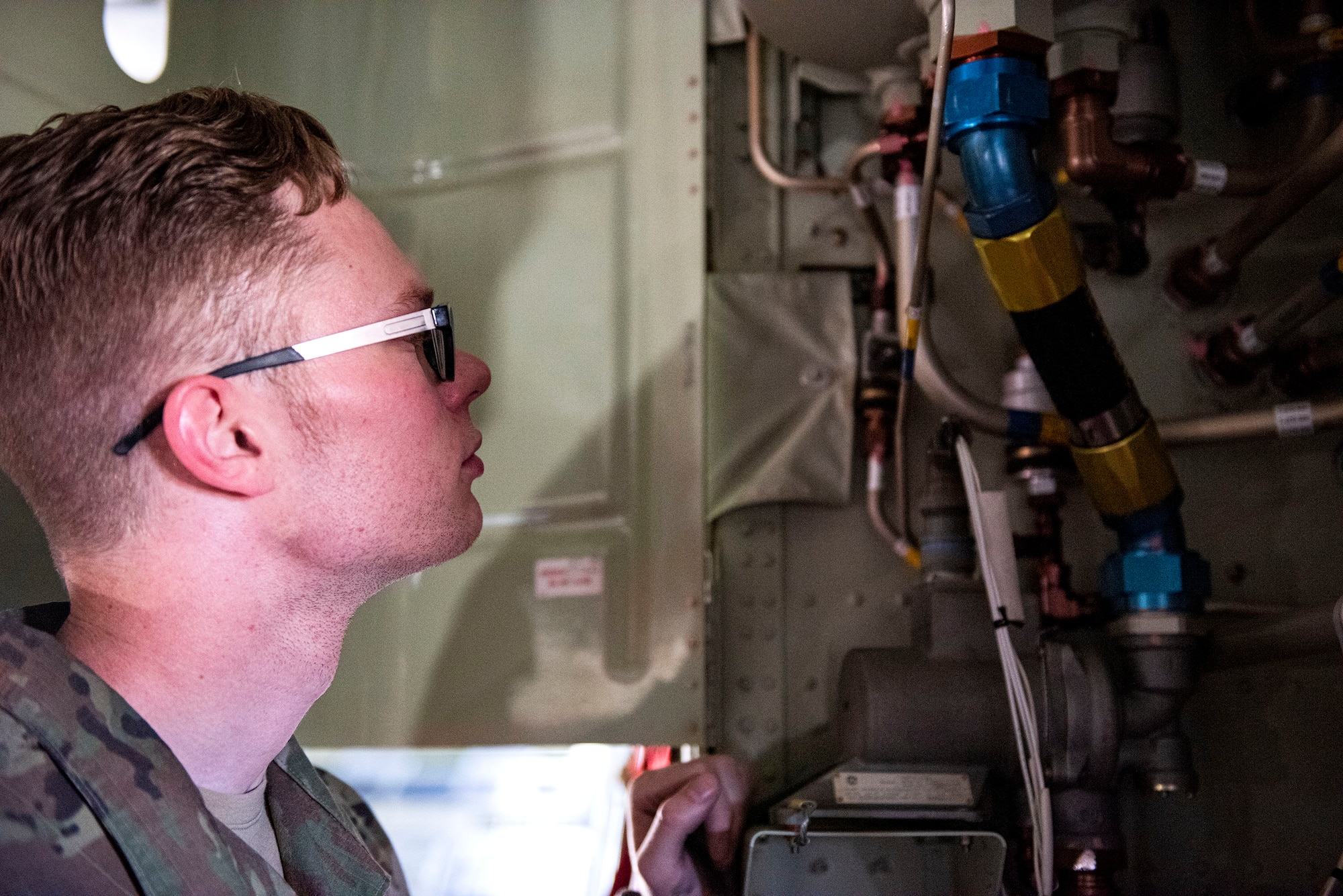 Photo of Airman examining a hydraulic system.