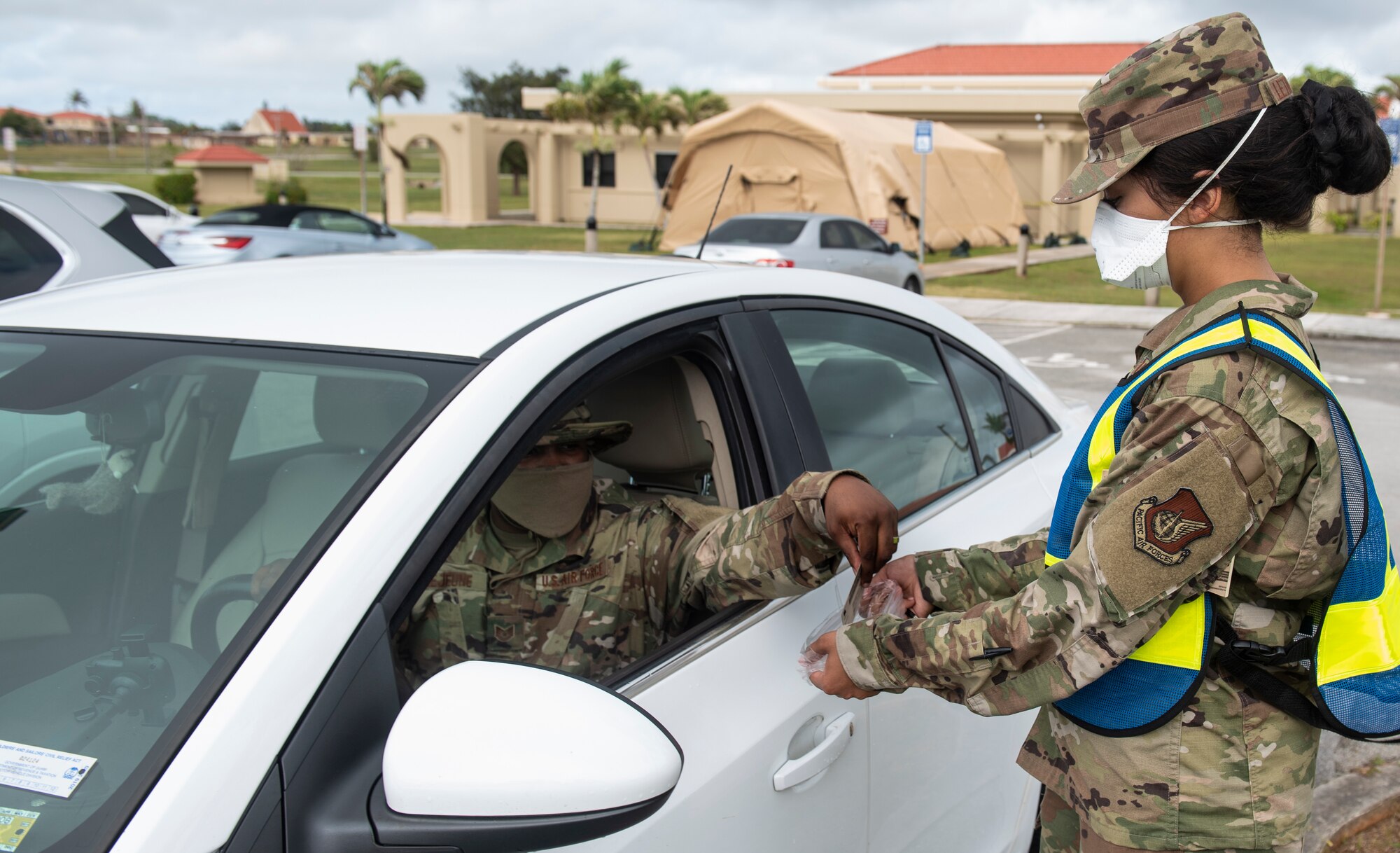 U.S. Air Force Tech Sgt. Charles Lejeune (left), 36th Medical Operations Squadron (MDOS) NCO in charge of dental logistics, give his I.D. to Senior Airman Patience Letourneau, 36th MDOS dental technician, to demonstrate a medication run at Andersen Air Force Base, Guam, May 16, 2020.