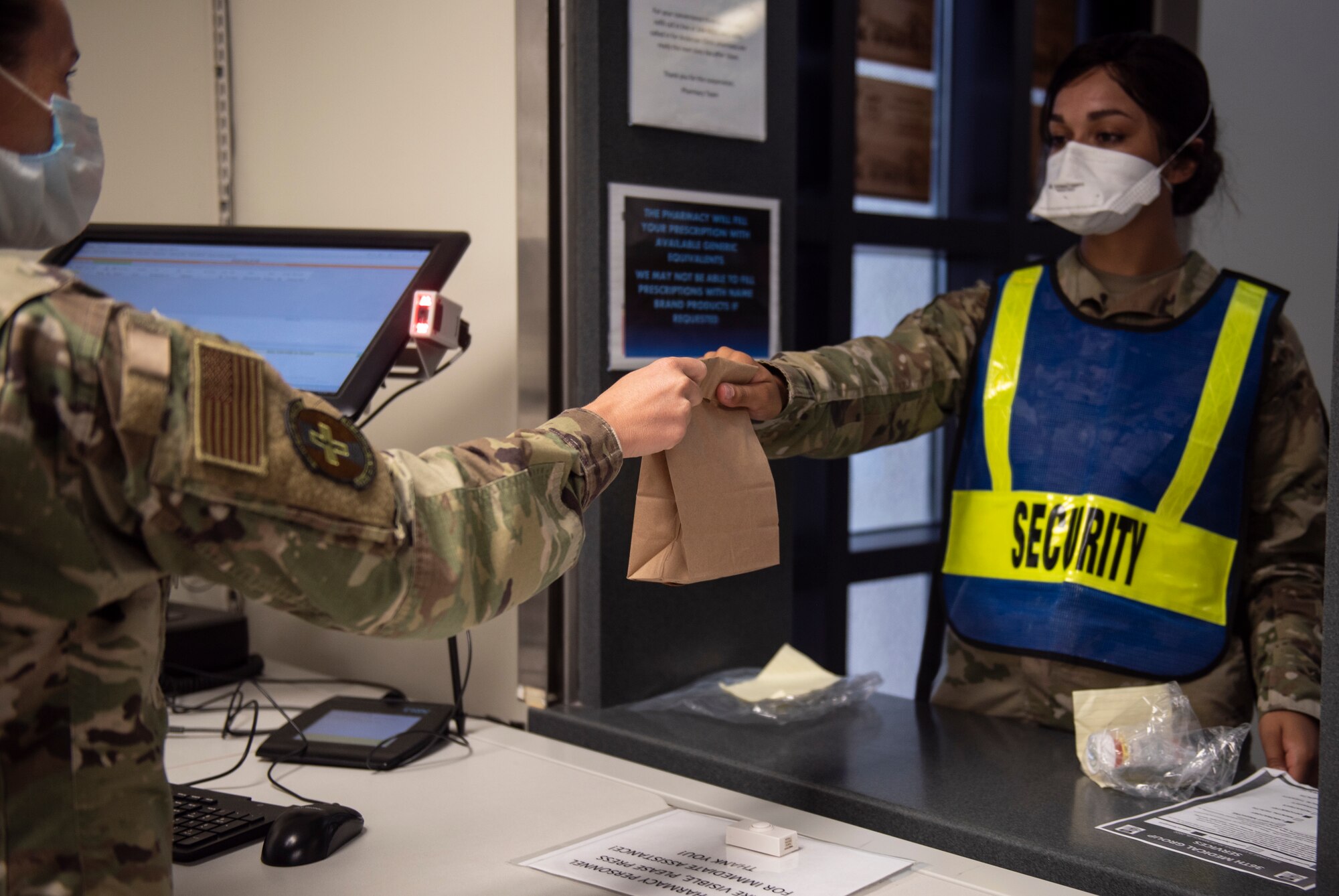 U.S. Air Force Tech Sgt. Amanda Dorsey (left), 36th Medical Support Squadron NCO in charge of pharmacy supply, gives medication to Senior Airman Patience Letourneau, 36th Medical Operations Squadron dental technician, at Andersen Air Force Base, Guam, May 16, 2020.