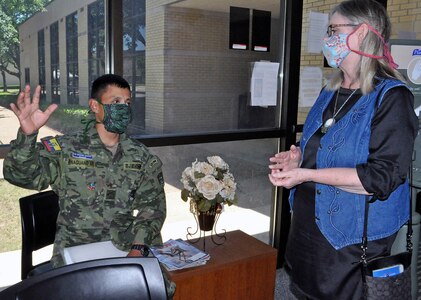 Sgt. Miguel Mesias Anaguano Gualoto (left), an Ecuadorian student at the Defense Language Institute English Language Center at Joint Base San Antonio-Lackland, discusses American and Ecuadorian cultures with Daisy Whisenant after she dropped off some facemasks she had made.