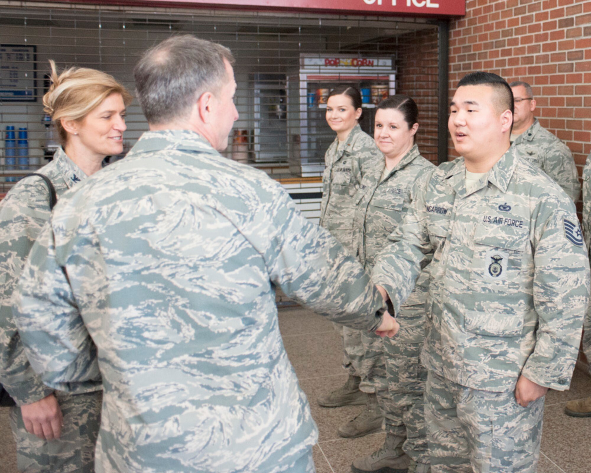 In this March 30, 2017 photo, Air Force Chief of Staff Gen. David L. Goldfein coins Tech. Sgt. Allen Nancarrow of the 102nd Security Forces Squadron, Massachusetts Air National Guard, at Otis Air National Guard Base. Goldfein served with Nancarrow's father, a retired master sergeant, in Italy. Allen Nancarrow is now a second lieutenant.