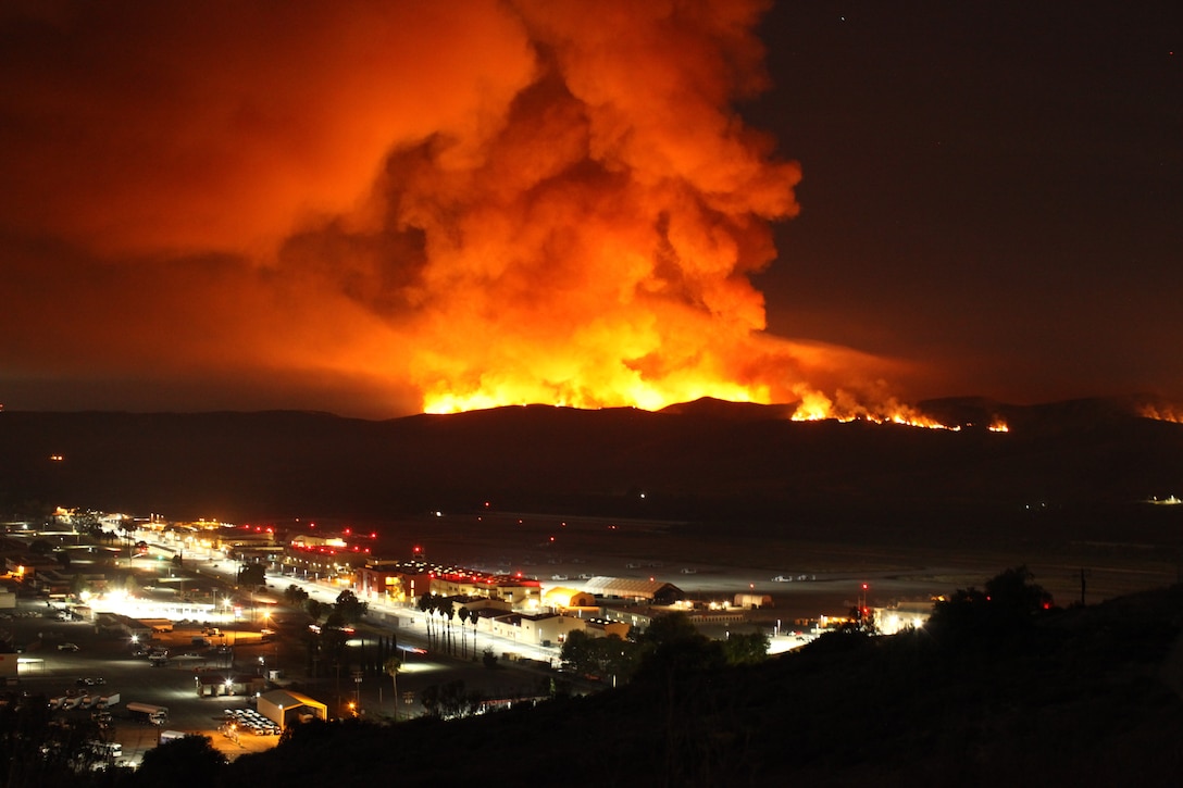 The Las Pulgas Fire burns behind the Marine Corps Air Station at Camp Pendleton, Calif., 16 May, 2014. The Las Pulgas Wildfire on Camp Pendleton has burned more than 15,000 acres and is the largest fire in San Diego County history. (U.S. Marine Corps photo by Sgt. Ethan Johnson/MCIW-MCB CamPen COMCAM/Released)