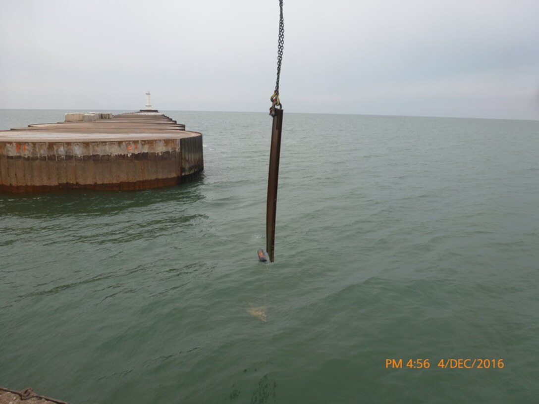 The U.S. Army Corps of Engineers, Buffalo District began repairs to the Lorain breakwater located in Lake Erie in the Port of Lorain, Lorain County, Ohio, on May 12.
The contractor, Great Lakes Dock and Materials, LLC, from Muskegon, Michigan, will complete the 2017 cell repair, consisting of a 50 linear foot void with a stone base and vertical sheet pile on top.  A cell of the Lorain breakwater was removed in 2017 due to it falling in disrepair.  Additionally, any remaining cracks will be repaired and solar powered lights will be added across both sides of the entire breakwater.