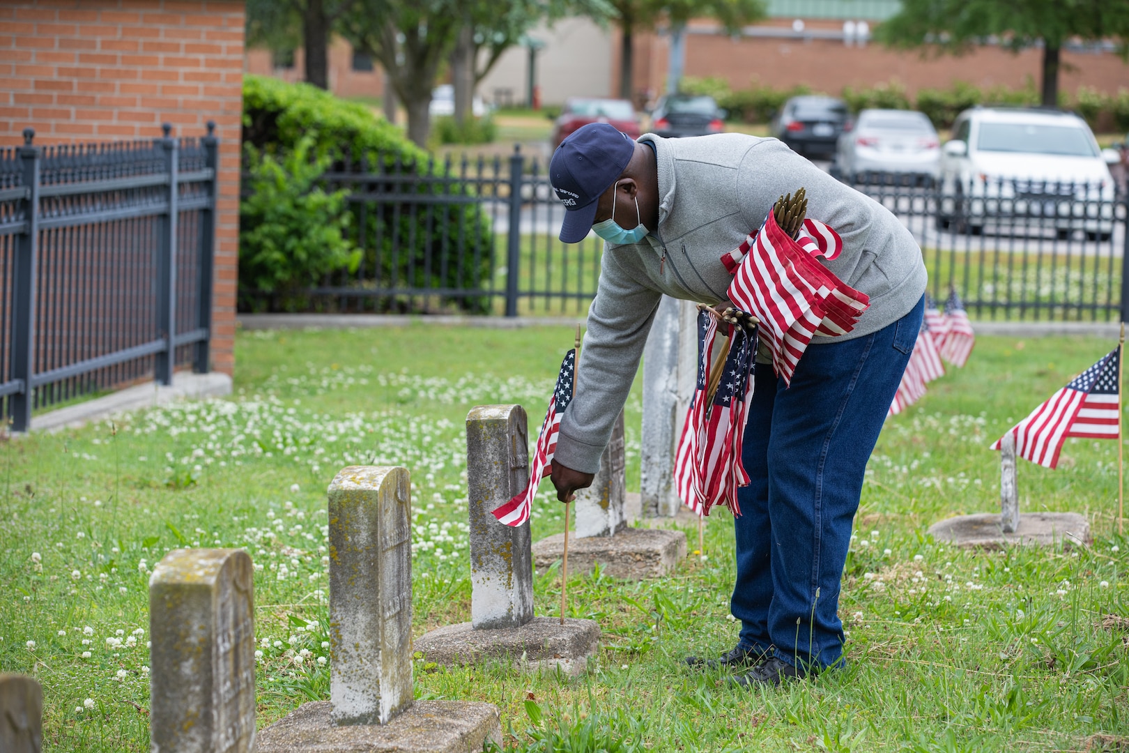 Veteran Employee Readiness Group Member Ricky Burroughs places a flag on the grave of a fallen service member at the Captain Ted Conaway Memorial Naval Cemetery.