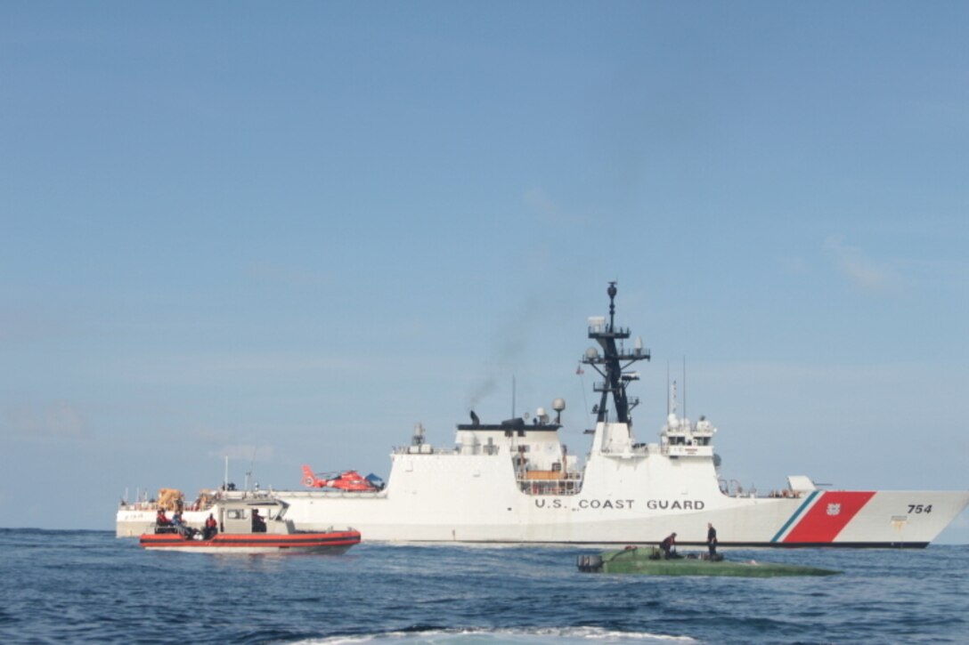 A low-profile go-fast vessel is shown next to the Coast Guard Cutter James.
