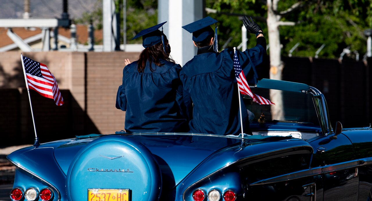 High school graduates ride in a graduation parade.