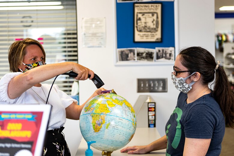 Photo of the Thrift Shop manager scanning a barcode.