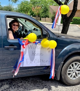 Jackie Polson helps to surprise U.S. Army Lt. Col. (Dr.) G. Travis Clifton, chief of general surgery, with a drive-by welcome home parade May 17, 2020, in San Antonio. Clifton and nearly 40 other Brooke Army Medical Center healthcare professionals deployed to New York City to assist in COVID-19 and other patient care.