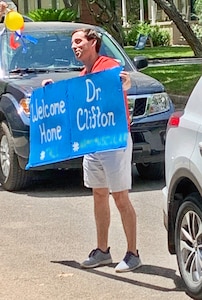 Dr. Phillip Kemp Bohan, general surgery resident, helps to surprise U.S. Army Lt. Col. (Dr.) G. Travis Clifton, chief of general surgery, with a drive-by welcome home parade May 17, 2020, in San Antonio. Clifton and nearly 40 other Brooke Army Medical Center healthcare professionals deployed to New York City to assist in COVID-19 and other patient care.