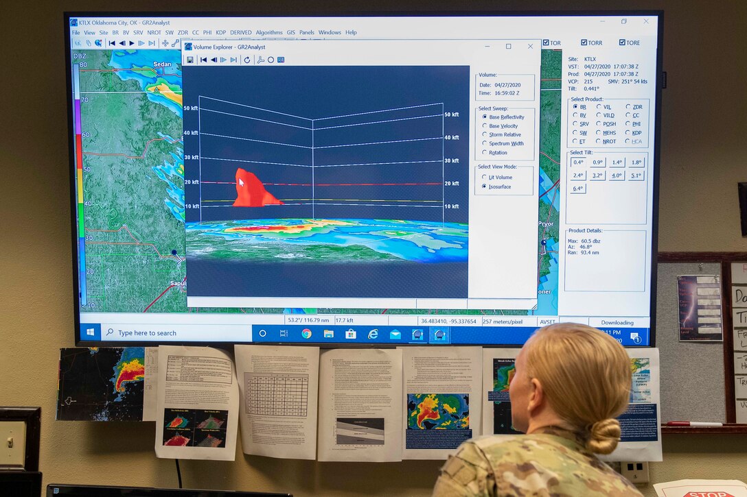 An airman looks at weather data on a screen.