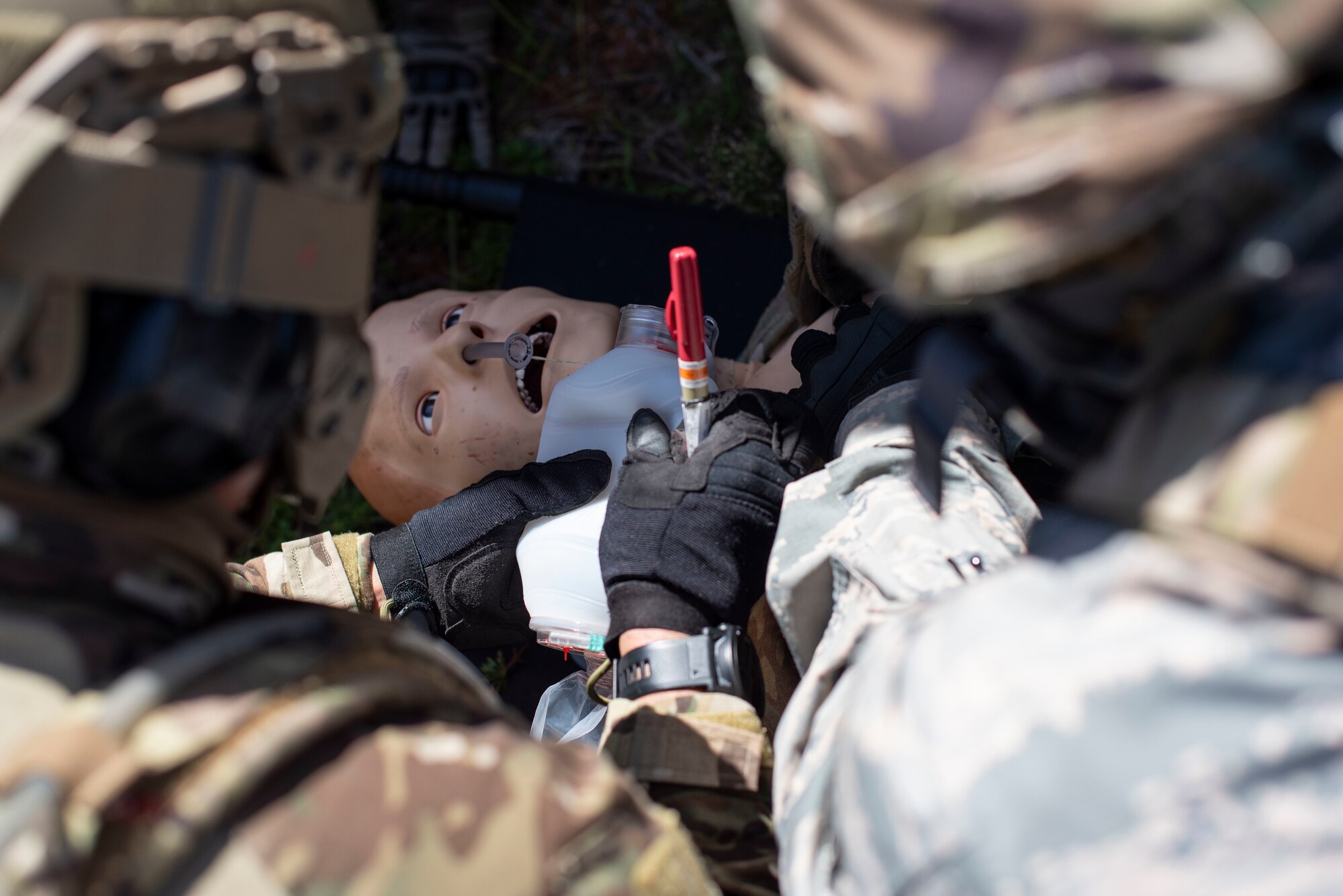 Students of a Tactical Combat Casualty Care class provide breaths to a simulated critically injured patient using a bag valve mask and prepare to perform needle decompression during the “care under fire” portion of the class, May 13, 2020 at Andersen Air Force Base, Guam.