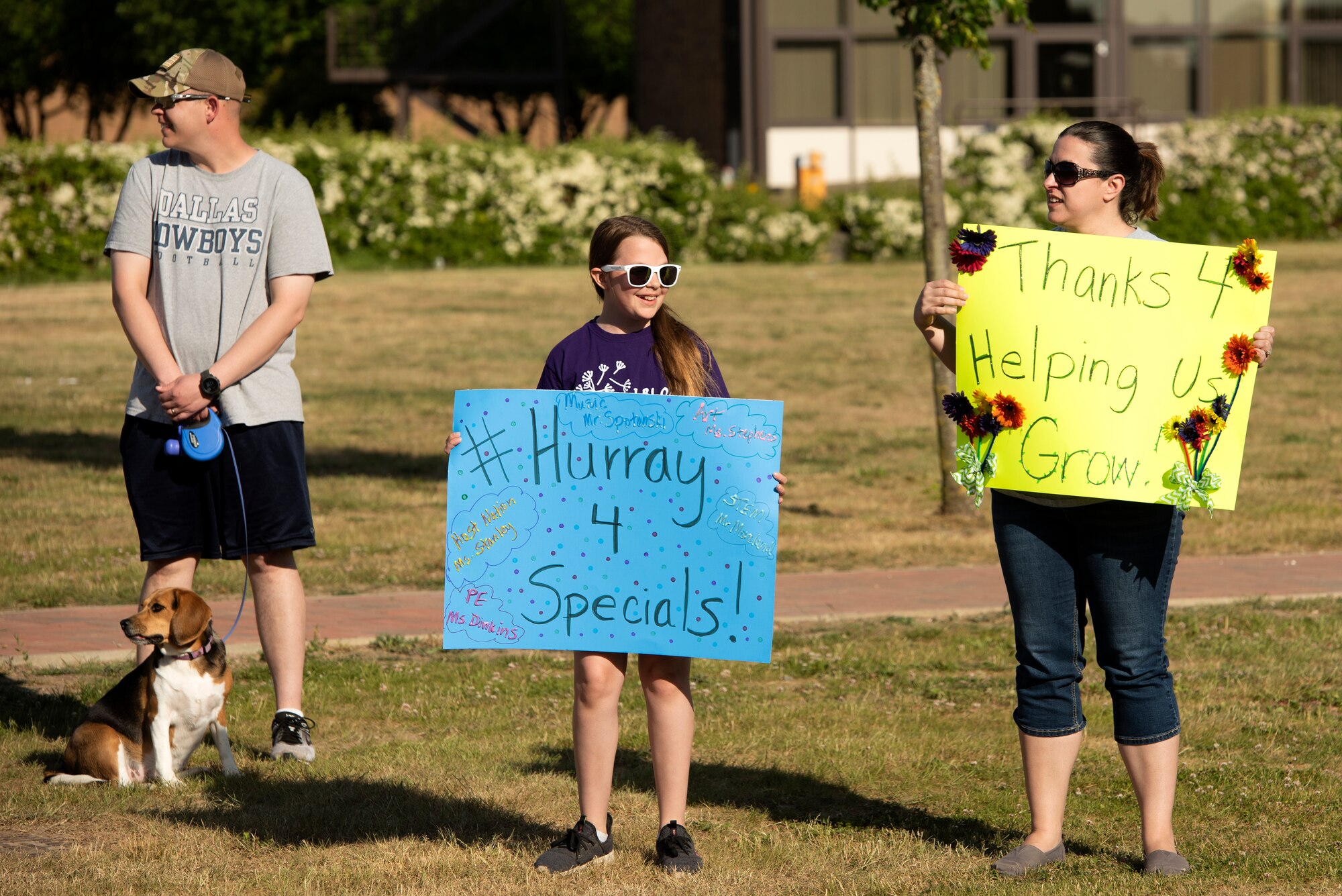 A Liberty Intermediate School student and family members hold signs to thank teachers at Royal Air Force Lakenheath, England, May 26, 2020. The parade was held as an end of school year "summer sendoff" for students, faculty, staff and family members. (U.S. Air Force photo by Airman 1st Class Jessi Monte)