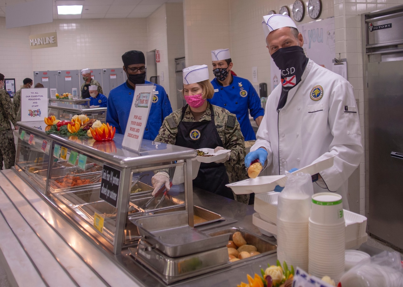 Sailors serving food during a staff appreciation luncheon.