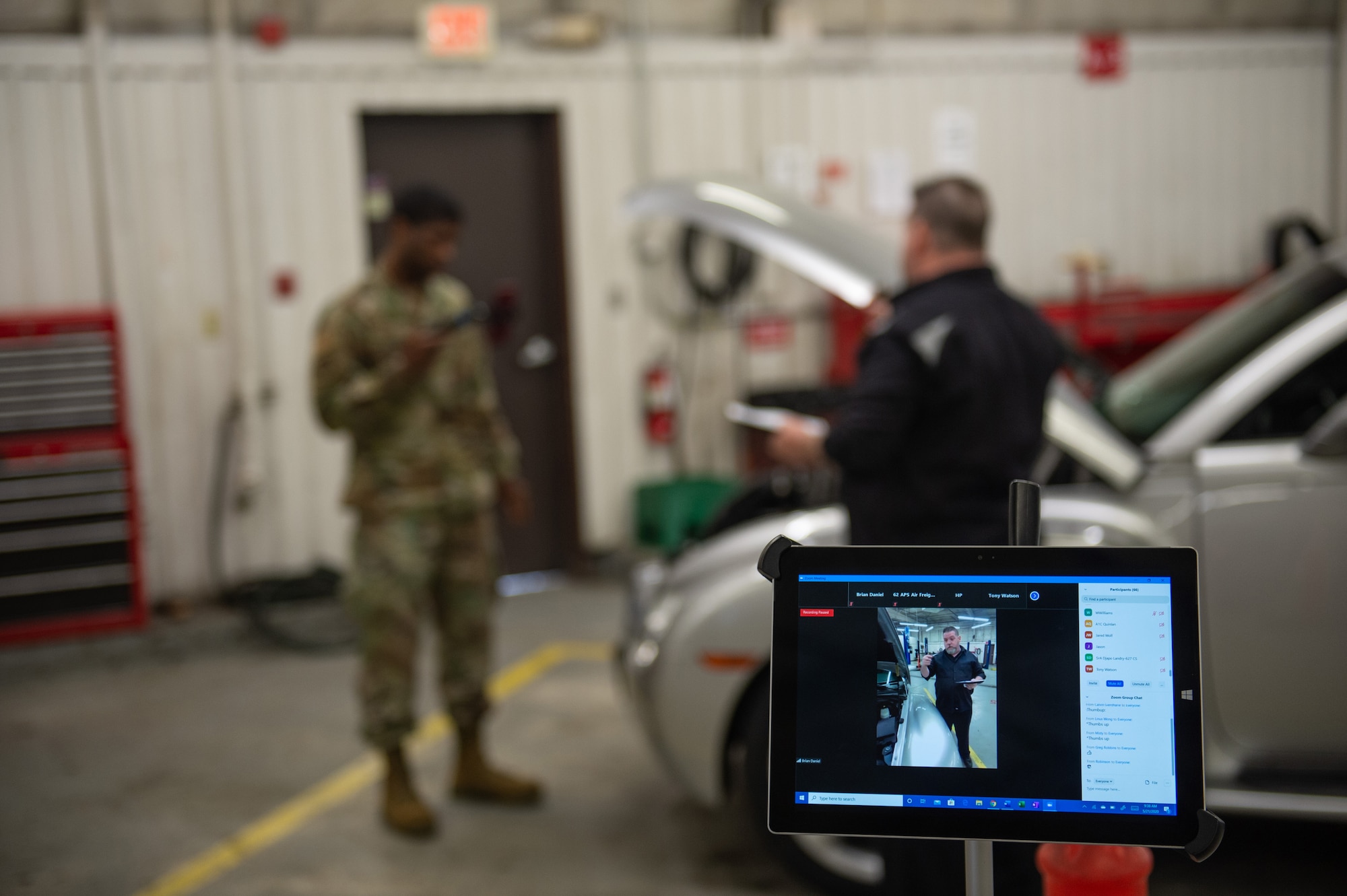 Staff Sgt. Brian Daniel, 62nd Maintenance Group quality assurance, left, and Steve Monchack, McChord Auto Skills Center technician, right, streams an auto mechanics class for Team McChord’s first virtual Wingman Day at Joint Base Lewis-McChord, Wash., May 21, 2020.