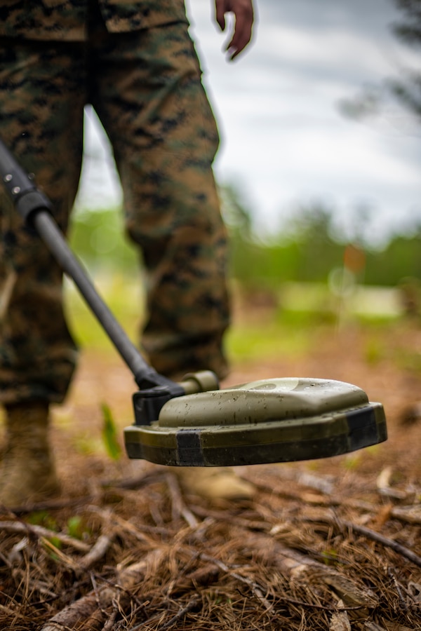 Lance Cpl. Cody Canada, a combat engineer with Special Purpose Marine Air-Ground Task Force - Southern Command, uses a metal detector to locate and identify simulated improvised explosive devices during a certification exercise at Marine Corps Base Camp Lejeune, North Carolina, April 23, 2020. The CERTEX is the culmination exercise that will test the training and readiness of the Marines and Sailors of the SPMAGTF-SC for certification to deploy. Once certified, the SPMAGTF-SC will be ready to conduct crisis response, theater security cooperation training and general engineering projects alongside partner nation militaries in Latin America and the Caribbean.  Canada is a native of Tacoma, Washington. (U.S. Marine Corps photo by Sgt. Andy O. Martinez)