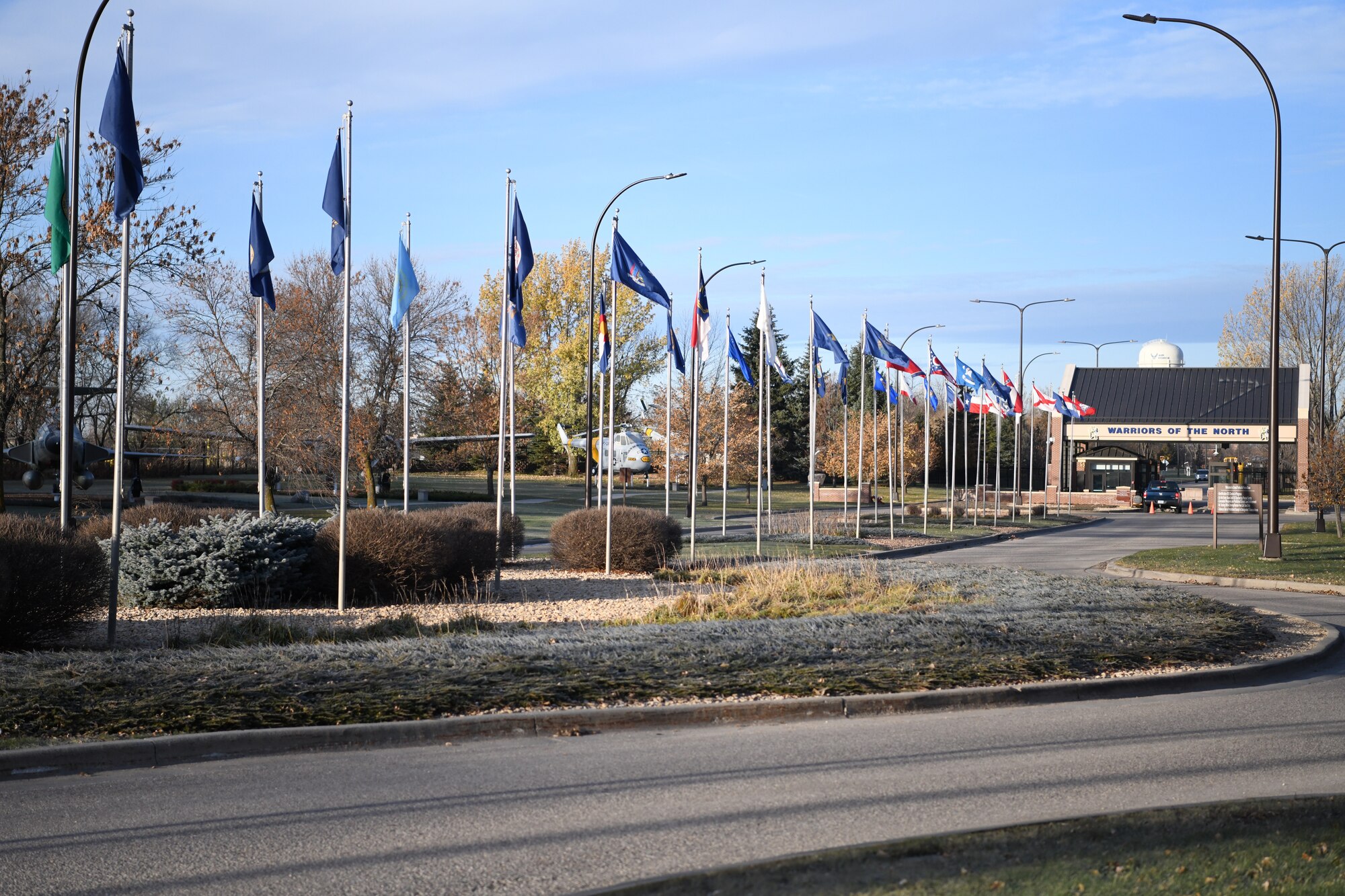 State flags lead up to the main gate of Grand Forks Air Force Base, North Dakota, Oct. 31, 2019. The base is home to the 319th Reconnaissance Wing, which was re-designated from the 319th Air Base Wing in June of 2019. (U.S. Air Force photo by Airman 1st Class Brody Katka)