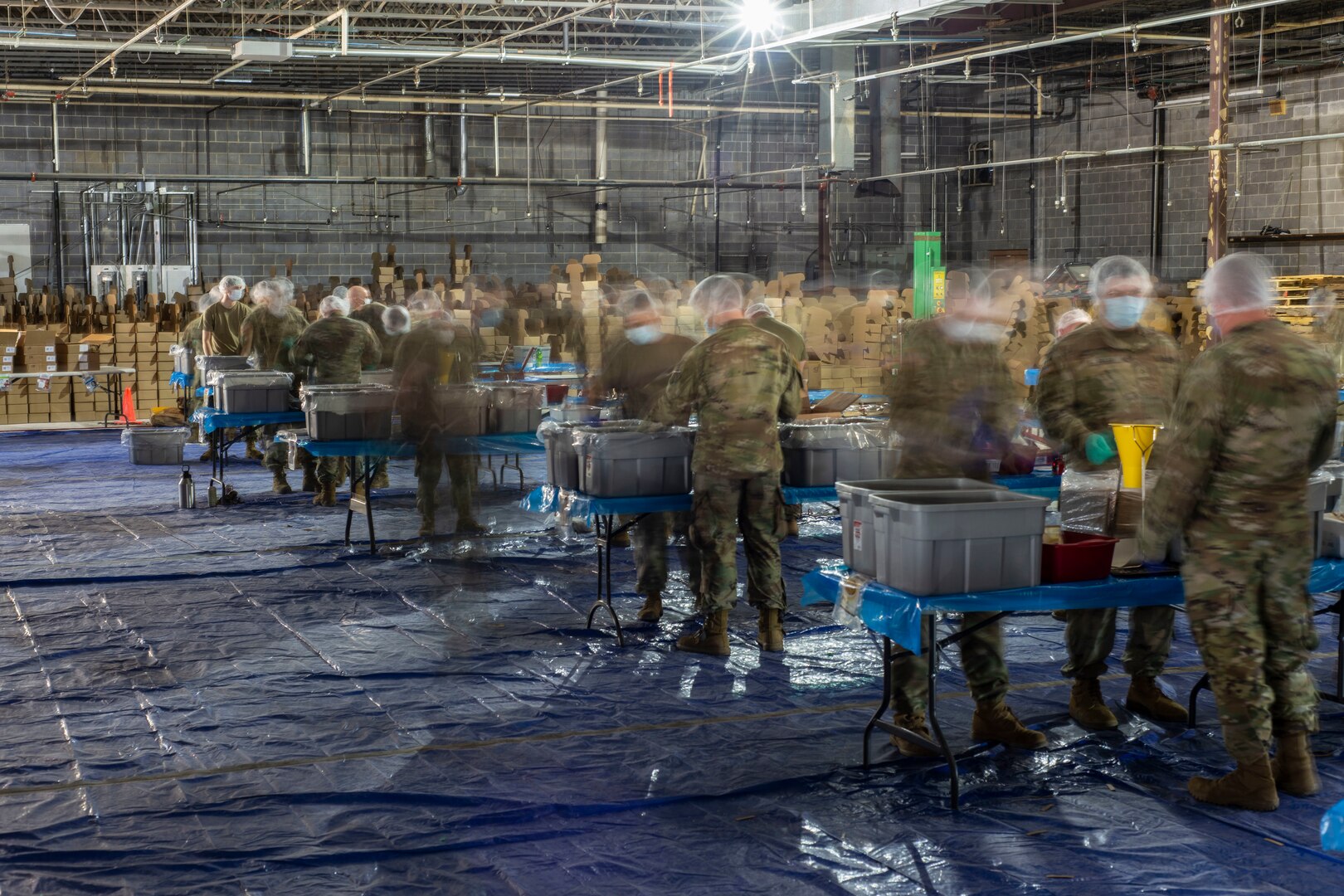 Soldiers of Company A, 2nd Combined Arms Battalion, 137th Infantry Regiment, measure out food in a boxed-meal assembly line operation in Leawood, Kansas, May 1, 2020. Kansas National Guard Soldiers, through The Outreach Program, packaged more than 2 million meals to be distributed to food banks across Kansas.