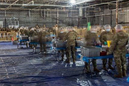 Soldiers of Company A, 2nd Combined Arms Battalion, 137th Infantry Regiment, measure out food in a boxed-meal assembly line operation in Leawood, Kansas, May 1, 2020. Kansas National Guard Soldiers, through The Outreach Program, packaged more than 2 million meals to be distributed to food banks across Kansas.