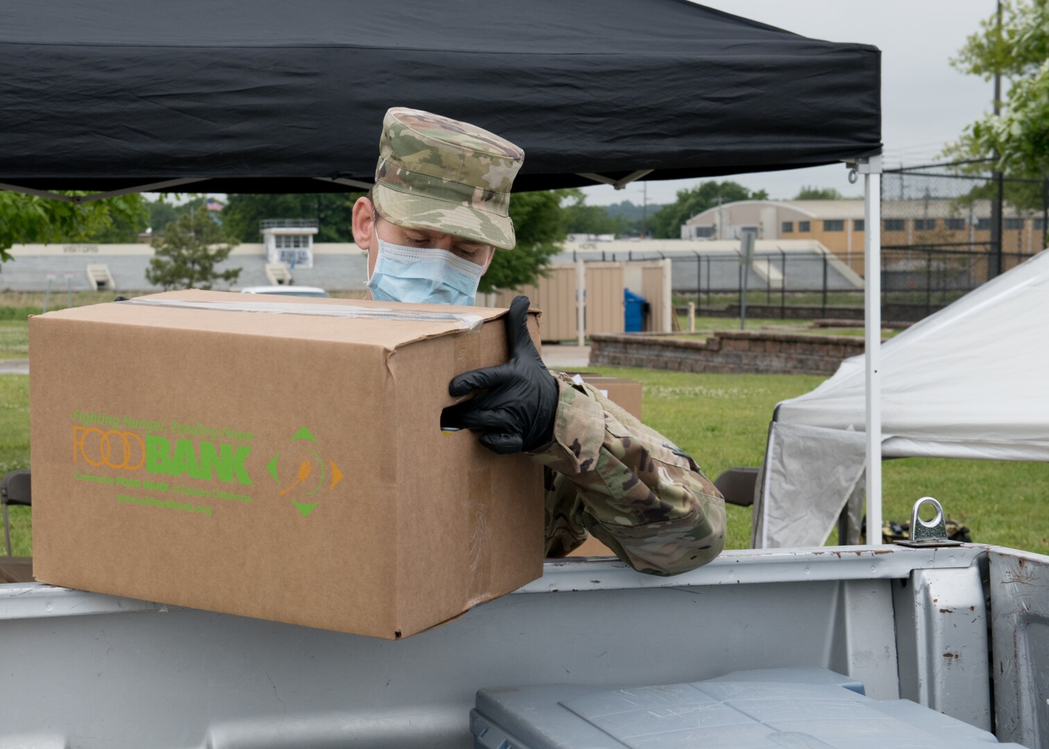 Staff Sgt. Nathan McElrath, a member of the 138th Fighter Wing, Oklahoma National Guard, loads food into a truck at a mobile food pantry May 13, 2020, in Tulsa, Oklahoma. Due to COVID-19, Guard members have been working at food banks to replace the vital volunteer force they rely on, until it is safe to have them return.