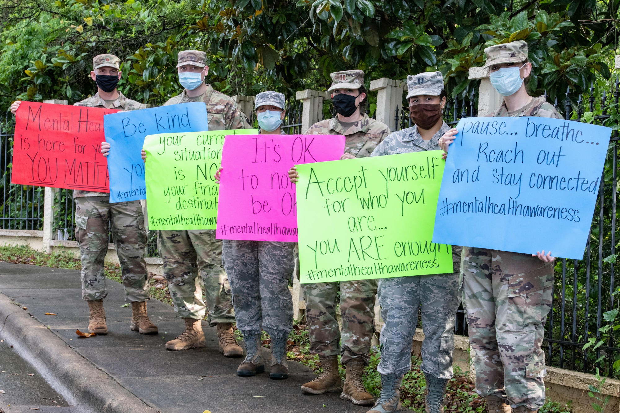 The mental health clinic team pose for a group photo with signs for mental health awareness month.