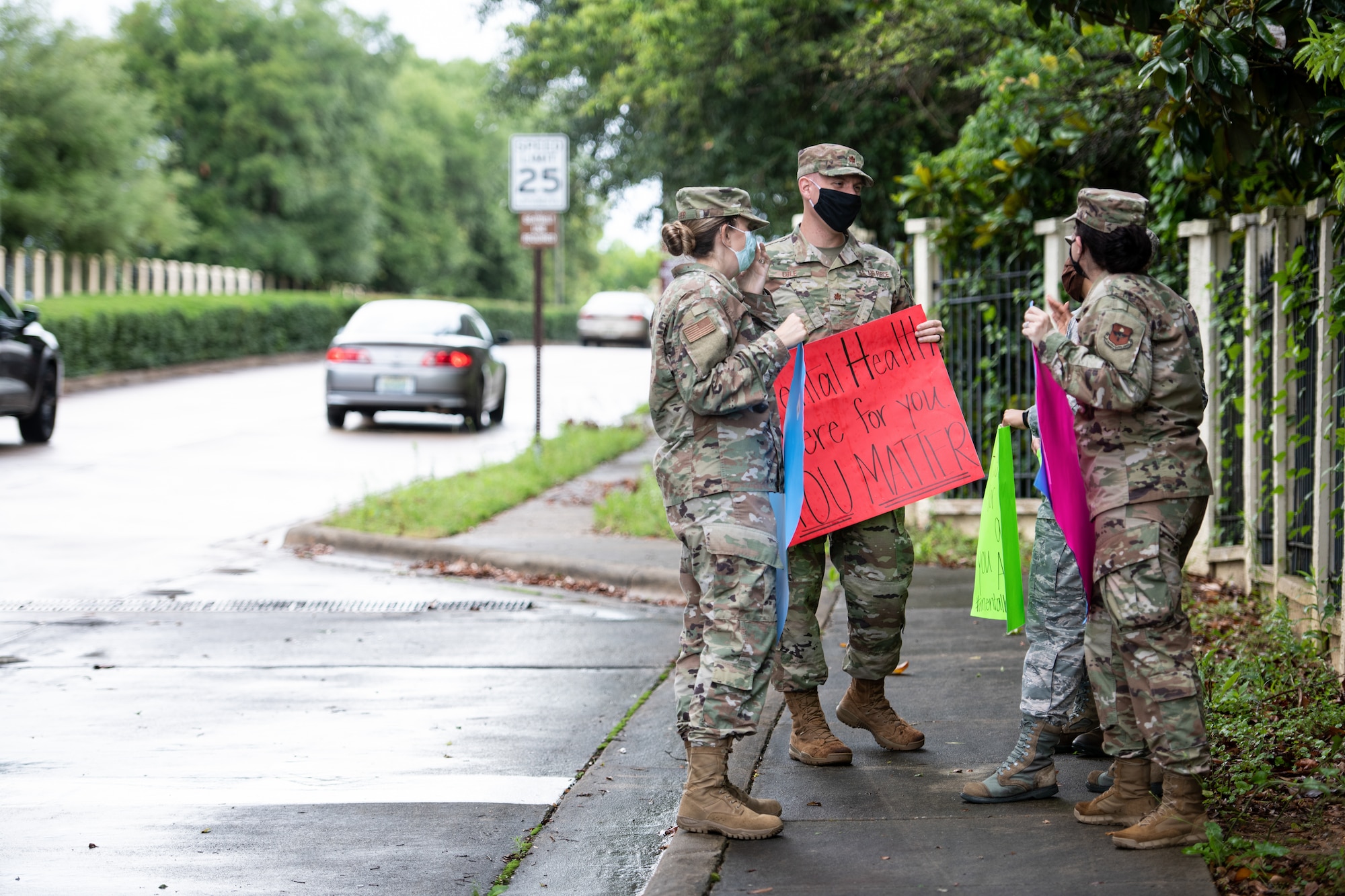 Airman from the mental health clinic stand in a group with signs they made for mental health awareness month.