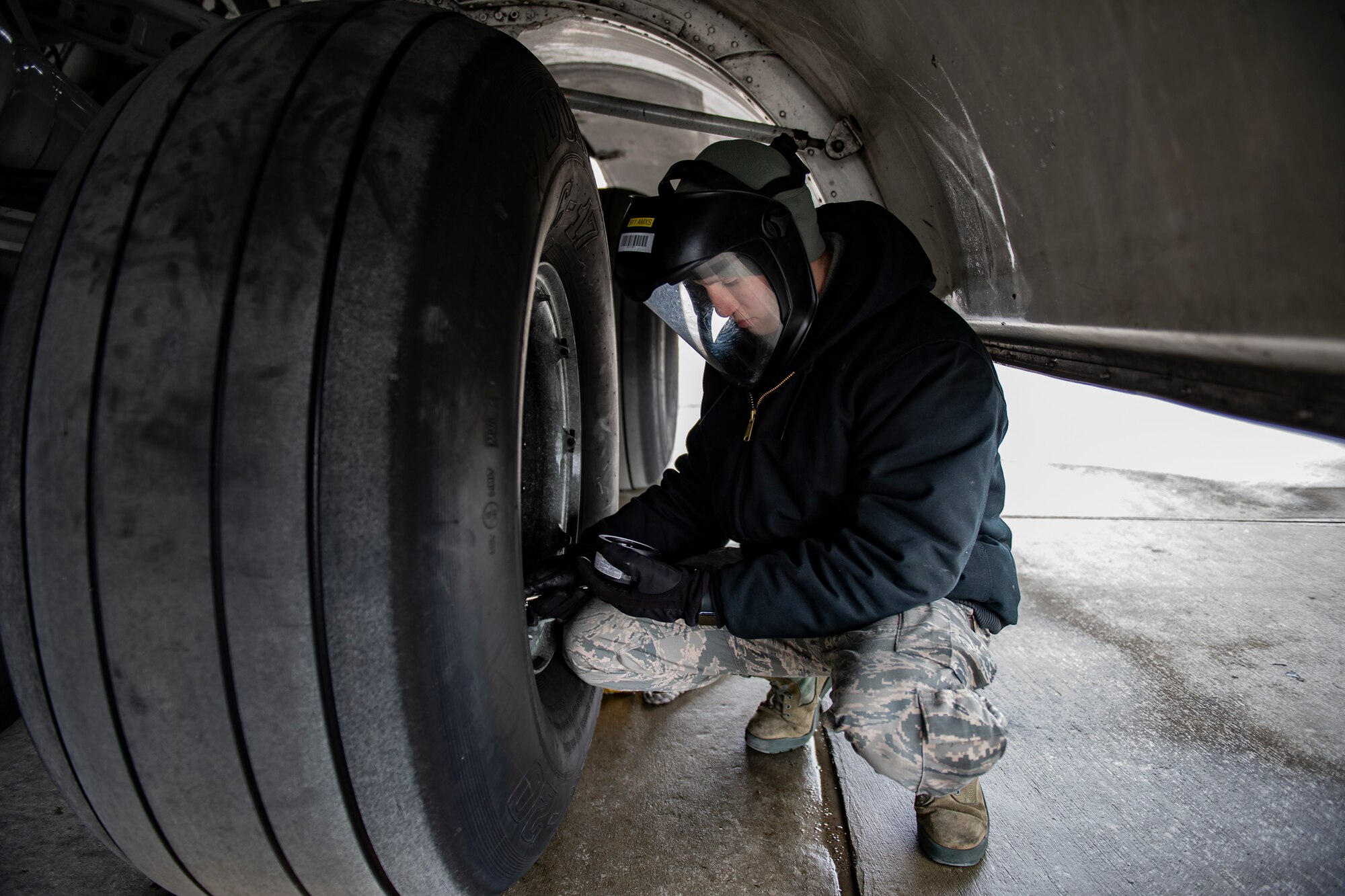 Senior Airman Zachary Anderson, 911th Aircraft Maintenance Squadron crew chief, checks the air pressure of a tire on a C-17 Globemaster III at the Pittsburgh International Airport Air Reserve Station, Pennsylvania, May 6, 2020.