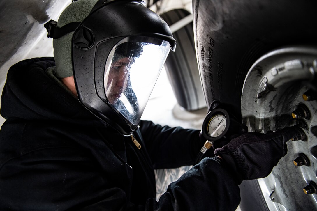 Senior Airman Zachary Anderson, 911th Aircraft Maintenance Squadron crew chief, checks the air pressure of a tire on a C-17 Globemaster III at the Pittsburgh International Airport Air Reserve Station, Pennsylvania, May 6, 2020.