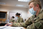 A member of the Oklahoma Army National Guard checks his list of contacts before making a phone call as part of contact tracing operations at the Texas County Health Department in Guymon, Oklahoma, May 15, 2020, in a multi-agency effort to slow the spread of COVID-19 in the state.