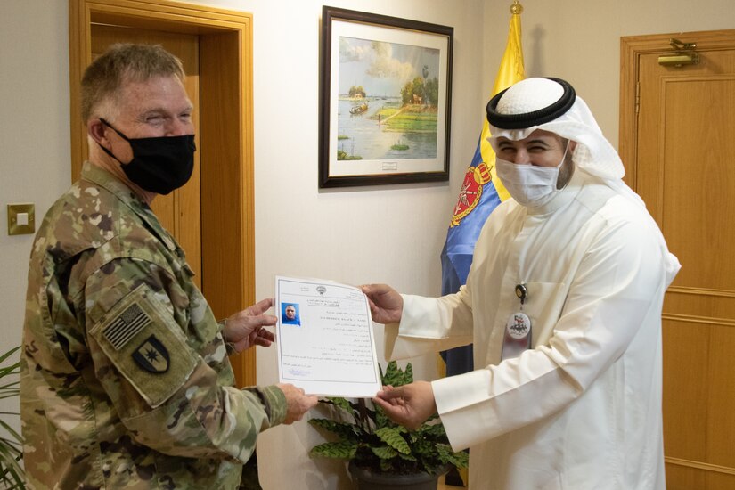 U.S. Army Col. Ian Black, command surgeon for the 1st Theater Sustainment Command, receives his Kuwaiti medical license from Sheik Abdullah M. Al-Sabah, chief of medical services for the Kuwait Ministry of Defense, at the Kuwait Armed Forces Hospital in Sabah Al Salem, Kuwait, May 19, 2020. Black is one of the first two U.S. military personnel now licensed to practice medicine at Kuwait Ministry of Defense hospitals, an initial step toward achieving medical interoperability between the two nations. (U.S. Army photo by Sgt. Sean Harding)