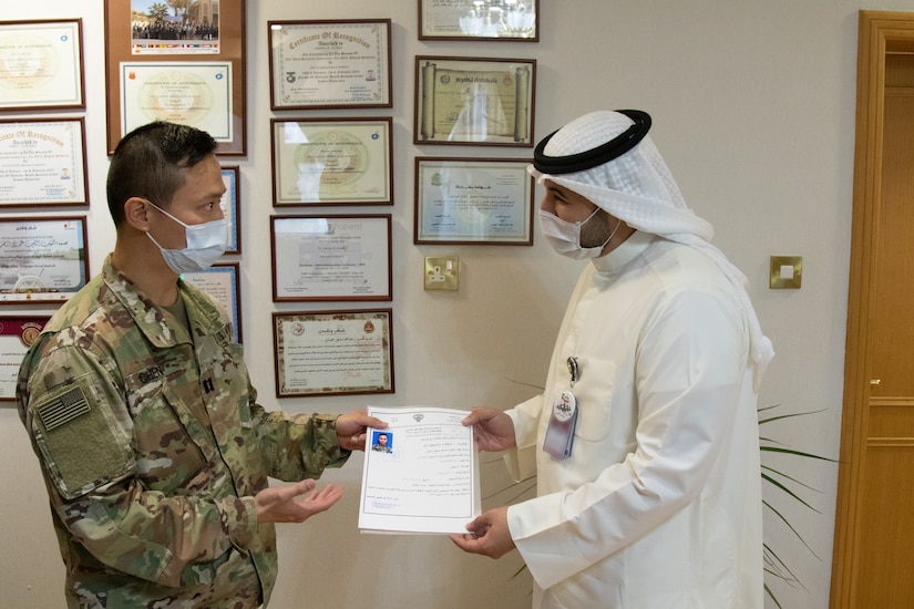 U.S. Army Capt. Yusheng Chen, a dentist with Area Support Group - Kuwait, receives his Kuwaiti medical license from Sheik Abdullah M. Al-Sabah, chief of medical services for the Kuwait Ministry of Defense, at the Kuwait Armed Forces Hospital in Sabah Al Salem, Kuwait, May 19, 2020. Chen is the first U.S. military dentist licensed to practice at Kuwait Ministry of Defense hospitals, an initial step towards medical interoperability between the two nations. (U.S. Army photo by Sgt. Sean Harding)