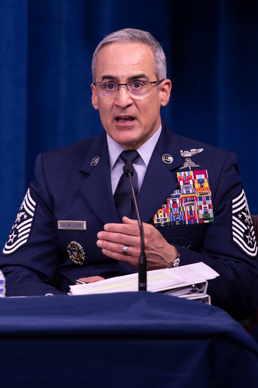 A man in uniform speaks into a microphone.